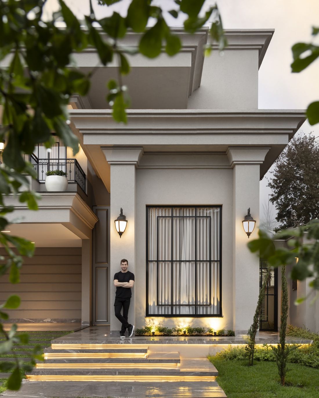 Fachada da Casa Dia à noite, com a escada de entrada iluminada