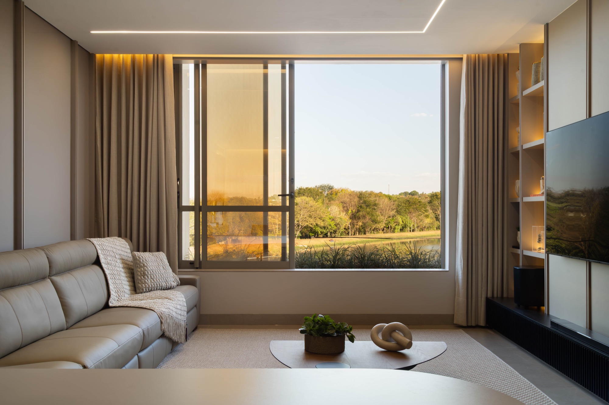 Ambiente da Casa Lago com ampla abertura de vidro voltada para o lago